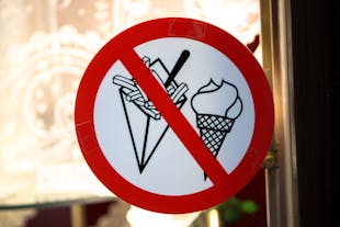 A sign in Brussels shows a prohibition on ice cream and fries in a restaurant setting.