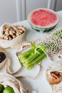 Various fresh vegetables and fruits in reusable bags, promoting a balanced and eco-friendly diet.